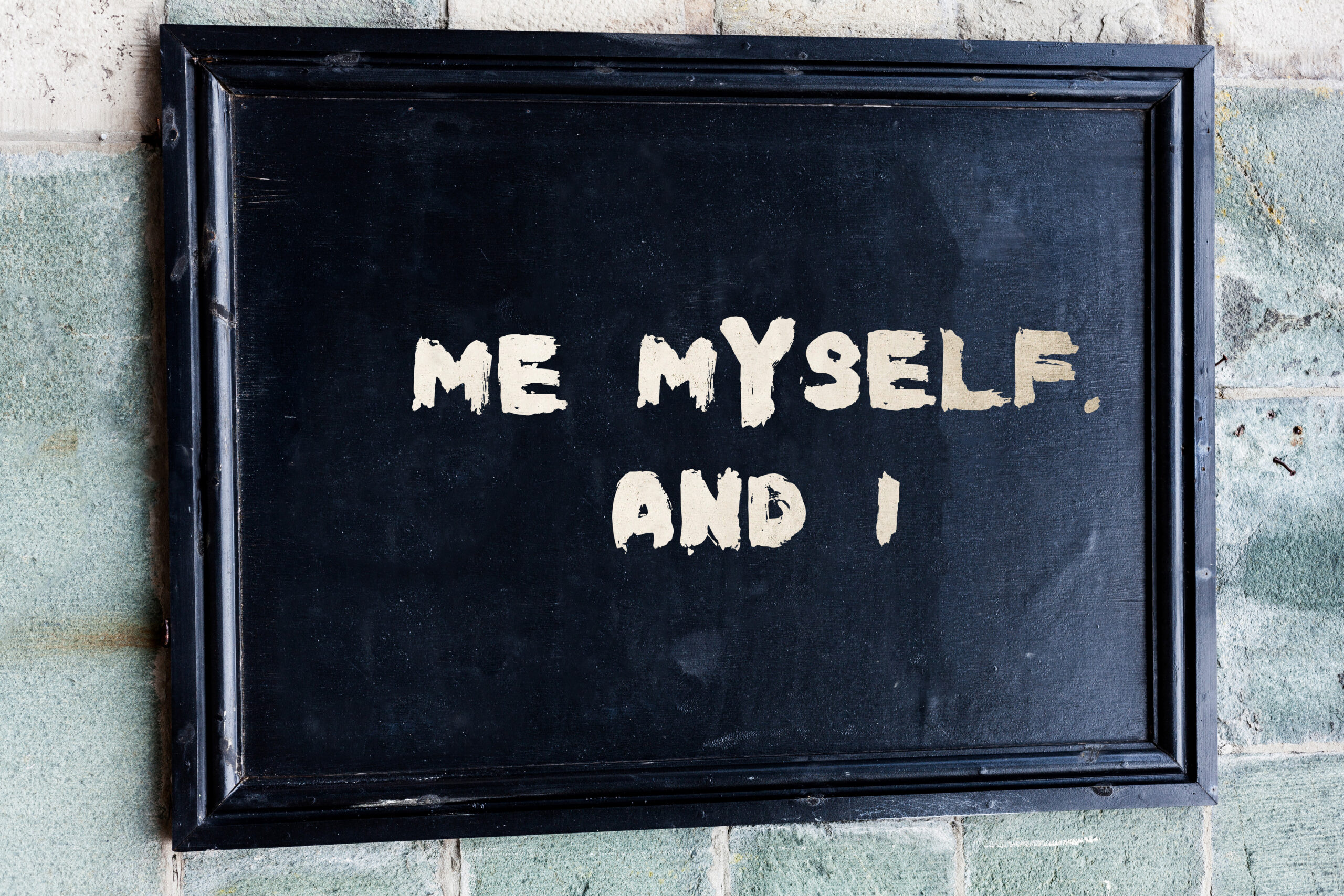 A blackboard with the words “Me Myself And I” written in chalk, representing the self-focus trap and the need to stop thinking about yourself.